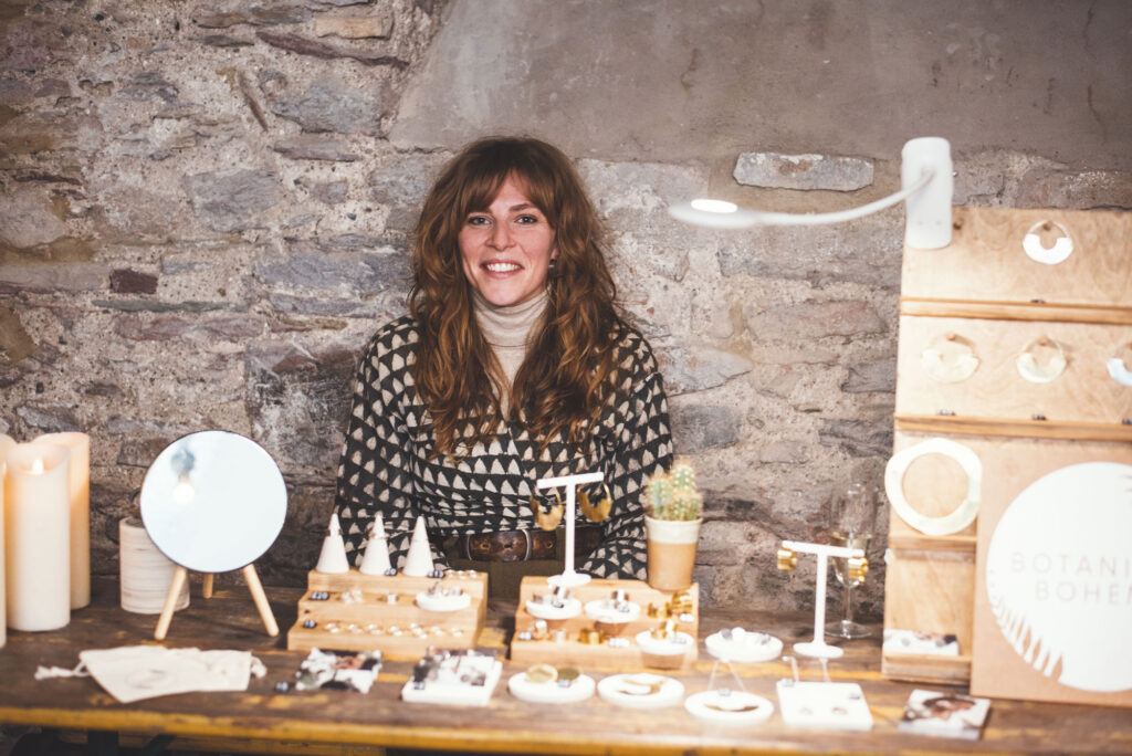 Stall holder Stevie Leigh-Smith of Botanical Boheme sat behind her stall at The Sail Loft Christmas Market in Dartmouth 2021