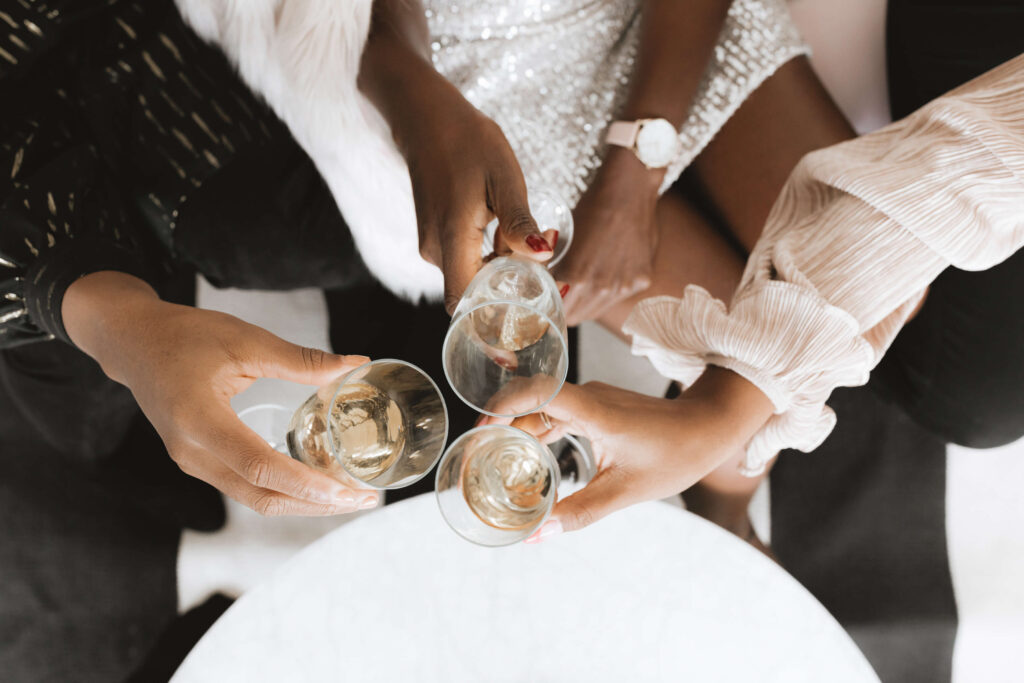Three women clinking champagne glasses at a networking event
